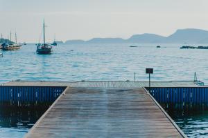 a wooden dock with a boat in the water at Hotel Nacional Inn Angra dos Reis in Angra dos Reis