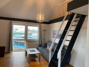 a living room with a couch and a spiral staircase at Hafenapartments-Aurich in Aurich
