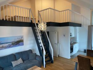 a living room with a couch and a spiral staircase at Hafenapartments-Aurich in Aurich