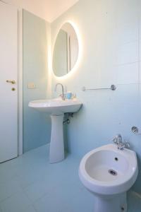 a white bathroom with a sink and a mirror at La casa di Visi in Milan