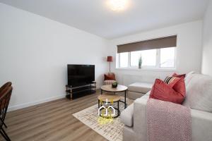 a living room with a couch and a tv at Cruden Bay Stay - SJA Stays - Modern 2 Bed Apartment in Cruden Bay