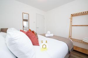 a bedroom with a white bed with a sign on it at Cruden Bay Stay - SJA Stays - Modern 2 Bed Apartment in Cruden Bay +9 photos