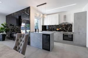 a kitchen with a counter and a stove top oven at Vila MaMe apartman s privatnim bazenom, besplatnim parkingom i wi - fi in Kaštela