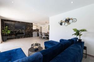 a living room with a blue couch and a table at Vila MaMe apartman s privatnim bazenom, besplatnim parkingom i wi - fi in Kaštela