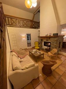 Una sala de estar con un sofá y una chimenea. en Grande maison vue mer exceptionnelle, en Vauville