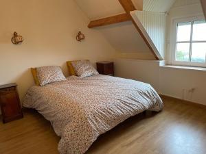 Un dormitorio con una cama y una ventana grande. en Grande maison vue mer exceptionnelle, en Vauville