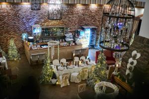 a dining room with a table and christmas trees at Hotel-Przystań in Kikół
