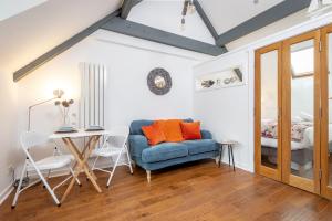 Una sala de estar con un sofá azul y una mesa. en WeeLoft - St Andrews Studio Apartment, en St Andrews