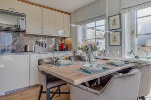 a kitchen with a wooden table with chairs around it at Ferienwohnung Waterkant in Munkmarsch