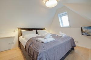 a bedroom with a bed with two towels on it at Ferienwohnung Waterkant in Munkmarsch