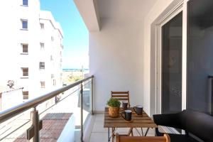 d'un balcon avec une table et une vue sur un bâtiment. dans l'établissement Harbor 101 Stylish 1BR Apartment in Larnaca, à Larnaka