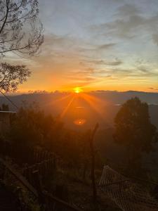 a sunset with the sun setting in the horizon at Uvi House & Restaurant in Mntindili +57 photos