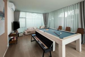 a living room with a pool table and a couch at Prime Deluxe Villa V17 in Na Jomtien
