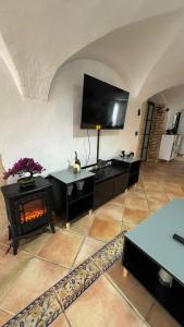 ein Wohnzimmer mit einem Kamin und einem Flachbild-TV in der Unterkunft Encantadora casa en Aroche in Aroche