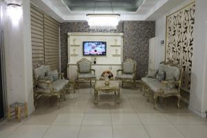 a living room with chairs and a tv on a wall at Grand Diamond Hotel in Mersin
