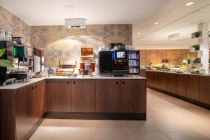 a kitchen with wooden cabinets and a counter top with a coffee shop at Thon Hotel Brussels City Centre in Brussels