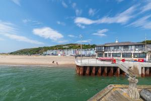 a view of a beach with a pier and a building at Fabulous Sea View Apartment in Aberdyfi