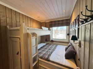 Un dormitorio pequeño con una litera y una ventana. en Kikut Panorama Geilo Ski-in Ski-out, en Geilo