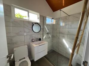 a bathroom with a toilet and a sink and a window at Refúgio com jacuzzi e vista mar in Estreito da Calheta +27 photos