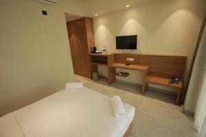 a hotel room with a bed and a television at The Brook Serene - A Nature Themed Boutique Resort, Kollam in Kottiyam +23 photos