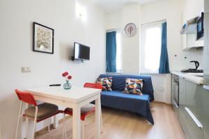 a living room with a table and a blue couch at Primopiano - Avogadro in Milan