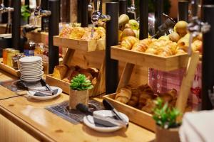 a bakery counter with baskets of bread and pastries at Hotel du Pin Nice Port in Nice