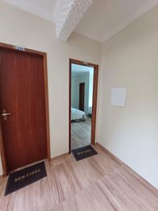 una habitación vacía con una puerta y un dormitorio en Pousada Estrela Mares Suíte 208, en Cabo Frío