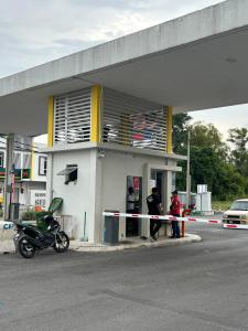 two people standing outside of a gas station at Zanayra Homestay in Melaka