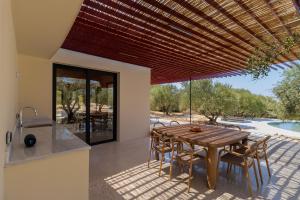 a kitchen and dining room with a wooden table and chairs at Villa Fengari in Evangelismós