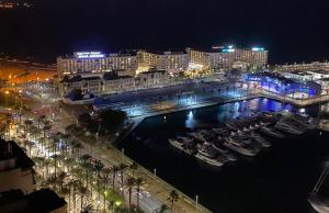 a city at night with boats in a harbor at Casas 349h Alicante Centre Second Floor in Alicante +23 photos