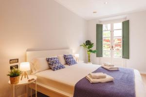 Un dormitorio blanco con una cama y una ventana. en Bravissimo Apartaments Mora 4, en Girona