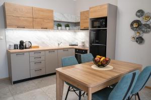 a kitchen with a wooden table with a bowl of fruit on it at SP Urban Apartment in Plovdiv