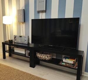 a flat screen tv sitting on a black entertainment center at Merikarhun kaksio - apartment by the sea, 5 mins off the highway in Kemi