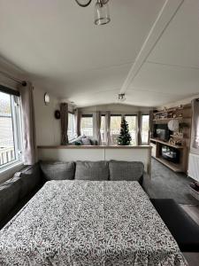 a living room with a bed and a couch at Anglers Rest, with Hot Tub and Private Fishing Peg in Tattershall