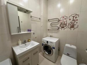 Un baño con lavadora y lavabo. en Silent center Apartment, en Járkov 31 fotos más