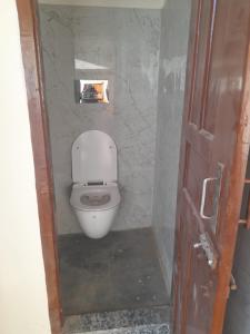 a bathroom with a white toilet in a room at Pink City Heritage Homestay in Jaipur
