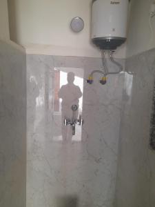 a man standing in a mirror in a bathroom at Pink City Heritage Homestay in Jaipur