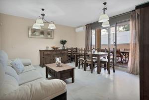 ein Wohnzimmer mit einer weißen Couch und einem Tisch in der Unterkunft Apartamento con terraza y piscina en Puerto Marina - MISTRAL in Benalmádena