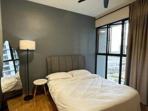 a bedroom with a bed and a lamp and a window at Admiral 3-Bedroom Retreat in Kota Laksamana Jonker in Melaka