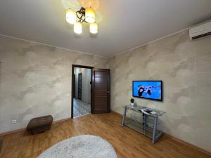 Una sala de estar con un televisor de pantalla plana en una pared. en Silent center Apartment, en Járkov