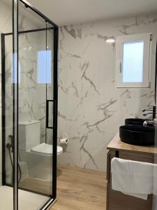 a bathroom with a glass shower and a toilet at Mestalla River Apartment in Valencia