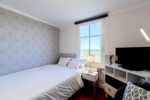 a bedroom with a bed and a flat screen tv at Boutique Hotel Villa Wahnfried Thiessow in Thiessow +275 photos
