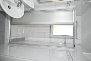 Un baño con lavabo y una ventana con mampara. en Einzelzimmer-07-OG-Meerblick, en Borkum