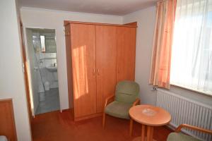 a room with a table and chairs and a bathroom at Zweibettzimmer-08-OG in Borkum