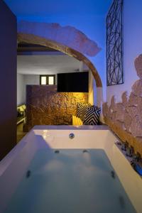 a bath tub in a room with a stone wall at Portoscalas 29 in Cagliari