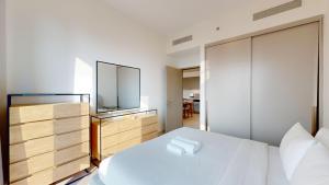 a bedroom with a white bed and a television at Grande Residence - Cosy One Bedroom in Downtown in Dubai +20 photos