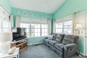 un salon avec un canapé et une télévision dans l'établissement Cozy Cottage in Bethany Beach, Delaware, à Frankford