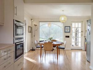 a kitchen and dining room with a table and chairs at Warner Wood - Selsey in Selsey