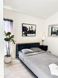 Un dormitorio con una cama grande y una maceta en Charming Poolside ADU Near SoFi Stadium - MK3LAD, en Los Ángeles