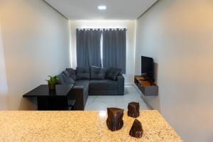 a living room with a couch and a tv at Condomínio Triângulo da Embaúba in Porto Seguro